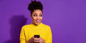 Smiling young woman holding smartphone – from Forbes
